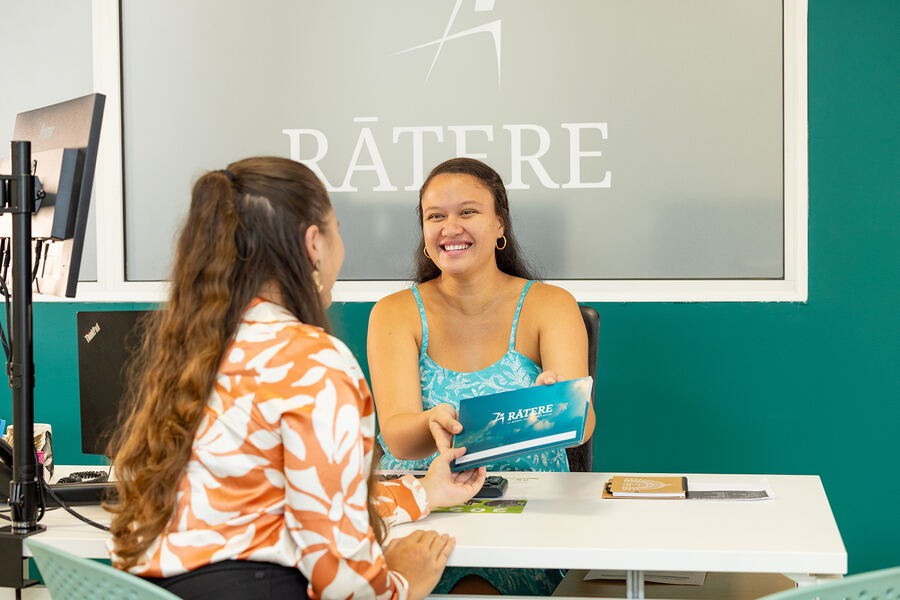 Une conseillère Ratere remet une brochure à une cliente
